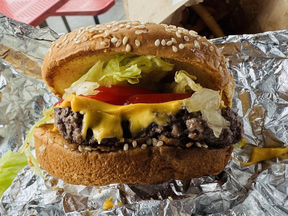 Cheeseburger with melted cheese, lettuce and tomato on a sesame bun